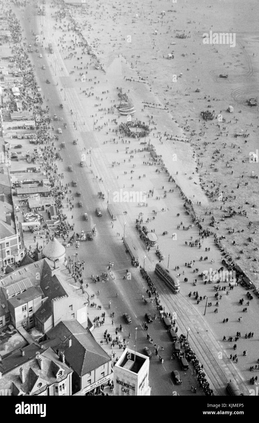 1940s view from the top of Blackpool Tower, a tourist attraction in Blackpool, Lancashire, England, which was opened to the public on 14 May 1894. Inspired by the Eiffel Tower in Paris, it is 518 feet (158 metres) tall and is the 120th tallest freestanding tower in the world. Blackpool Tower is also the common name for Tower buildings, an entertainment complex in a red-brick three-storey block comprising the tower, the ground floor aquarium and cafeteria, Tower Circus, the Tower Ballroom and roof gardens that was designated a Grade I listed building in 1973. Stock Photo