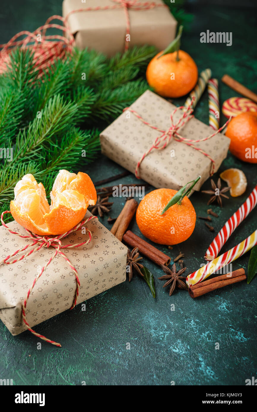 Fresh mandarins with leaves, candy canes, gift boxes in kraft paper and ...