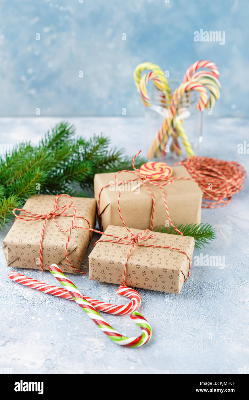 Gift boxes in kraft paper, candy canes and branch of Christmas trees on ...