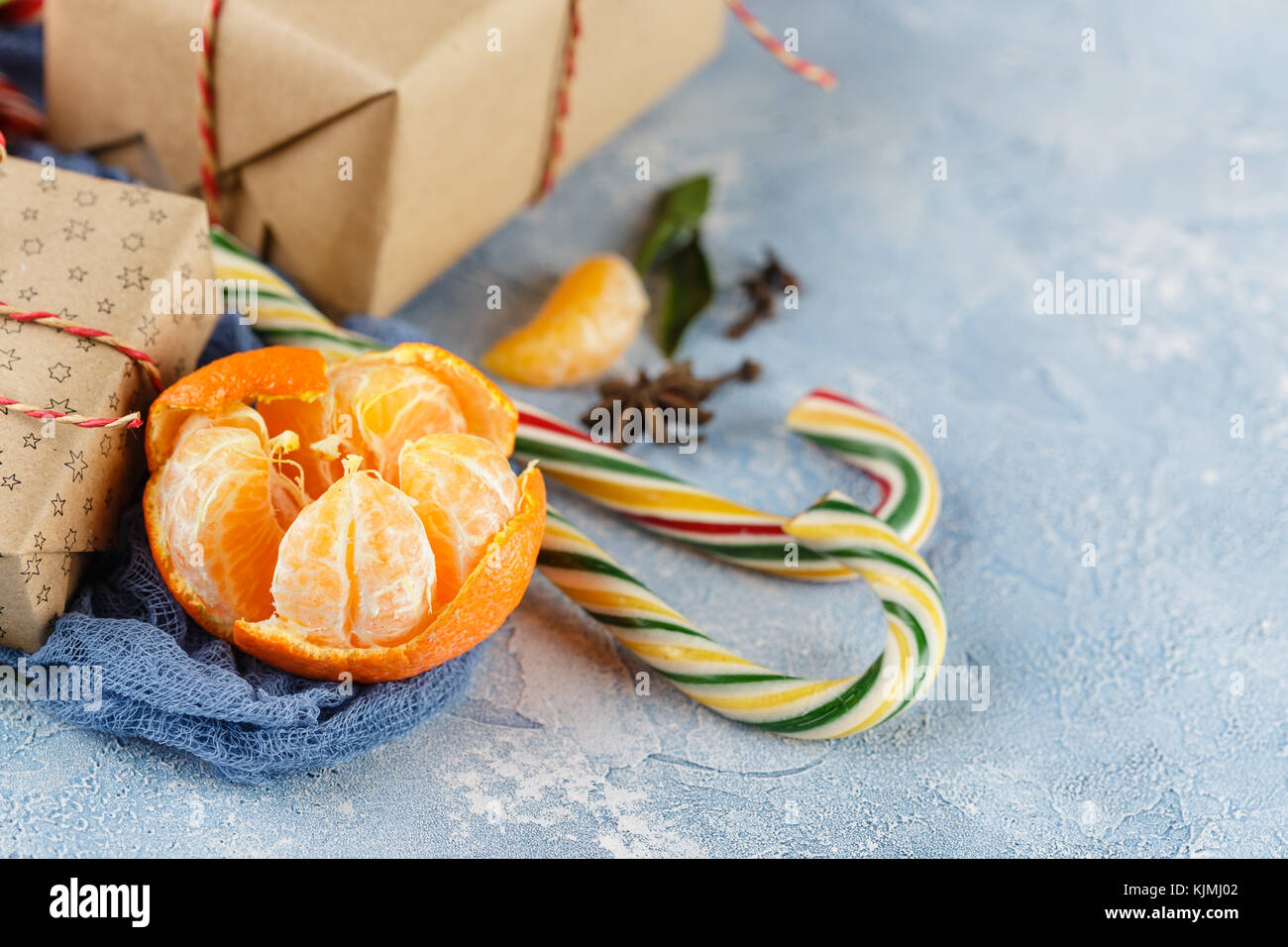 Fresh mandarins with leaves, candy canes, gift boxes in kraft paper and ...
