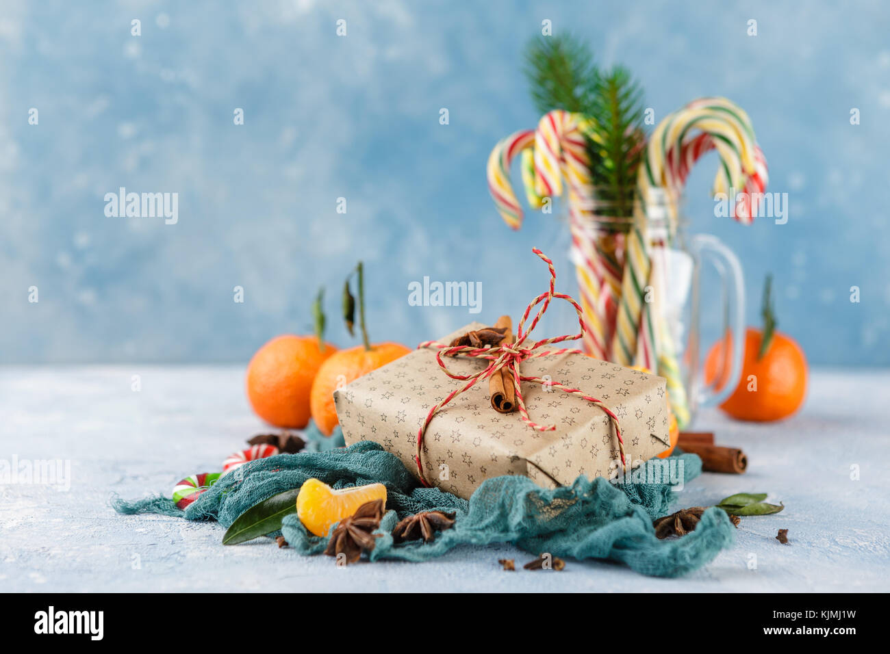 Fresh mandarins with leaves, candy canes, gift boxes in kraft paper and ...