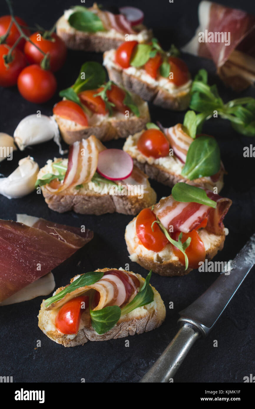 Homemade bruschettas with bacon and grilled tomato,selective focus Stock Photo
