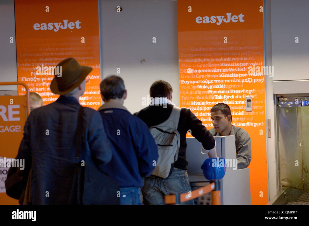 easyJet check-in queue with businessmen in suits with carry-on baggage Stock Photo