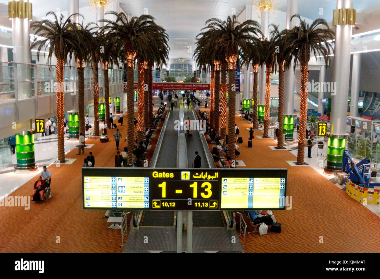 The Sheikh Rashid passenger terminal at Dubai International airport. Elevated view, passengers using travelators and walking along. Large open spaces  Stock Photo