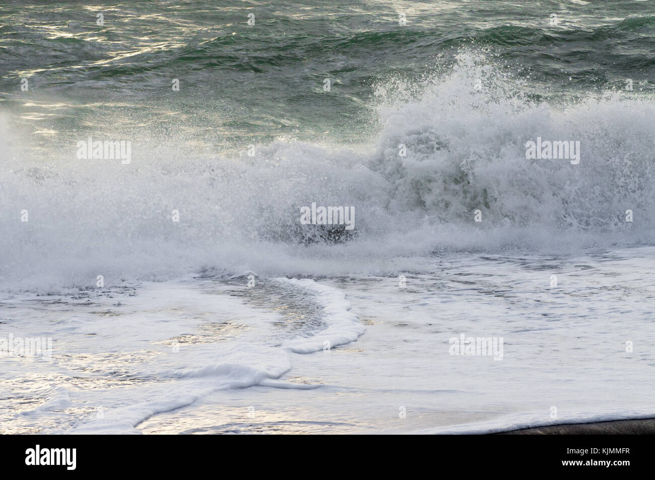 Splashing sea wave crashing against the shore with foam Stock Photo - Alamy