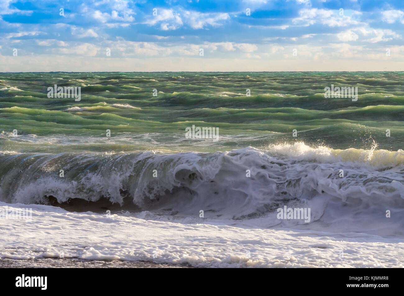 Beautiful green waves on a storm sea and blue sky Stock Photo - Alamy