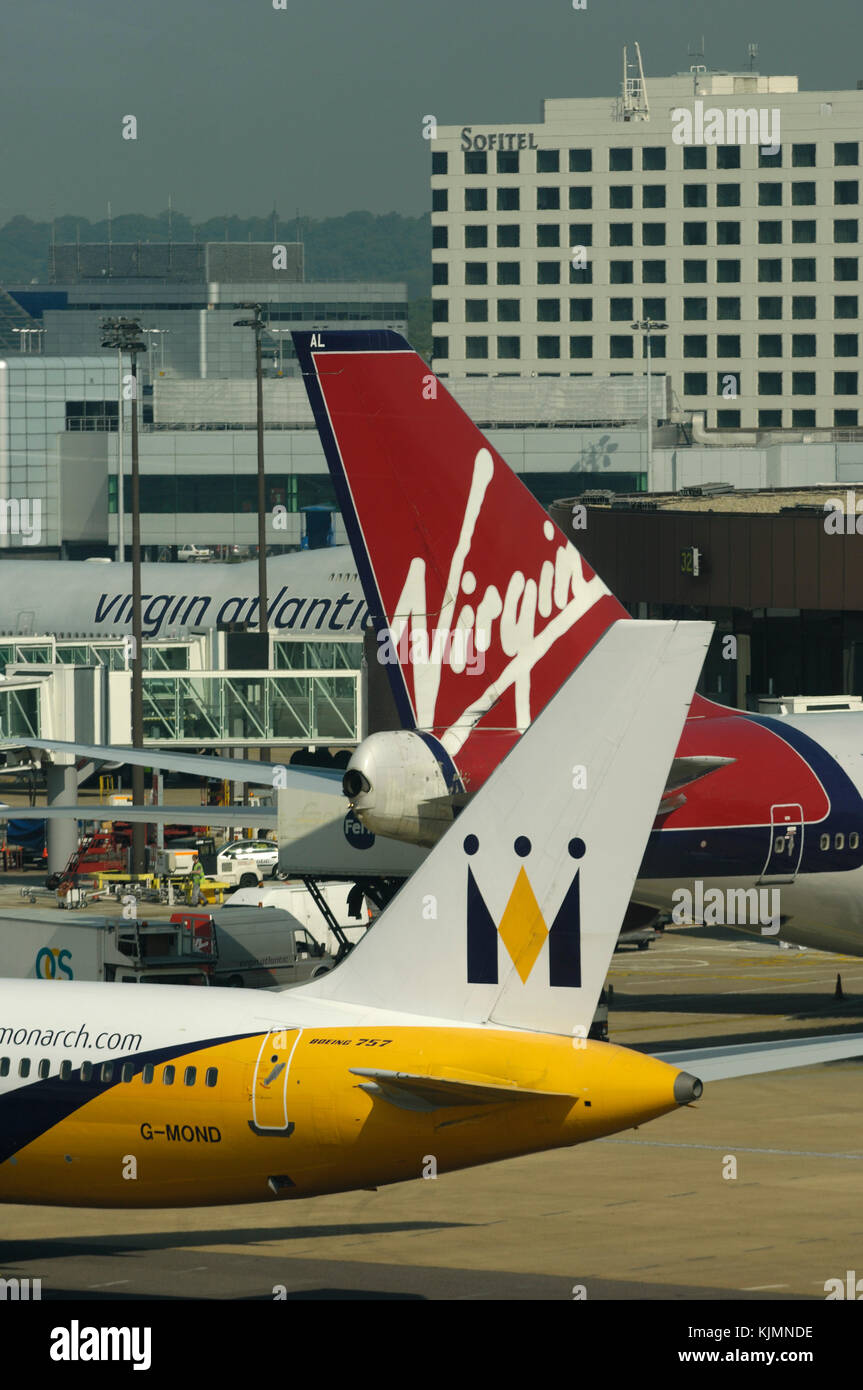 tails of a Monarch Boeing 757-200 and Virgin Atlantic 747-400 with the Sofitel Hotel behind Stock Photo