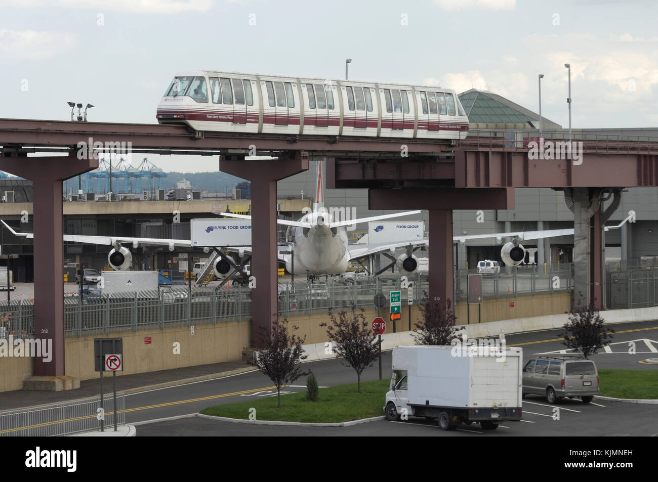 a passenger monorail with an Air France Airbus A340 parked at the terminal and Flying Food catering trucks behind Stock Photo