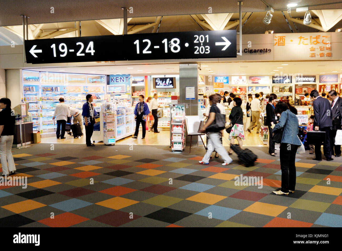 airport signs and duty-free shops in the main terminal, with multi coloured floor Stock Photo