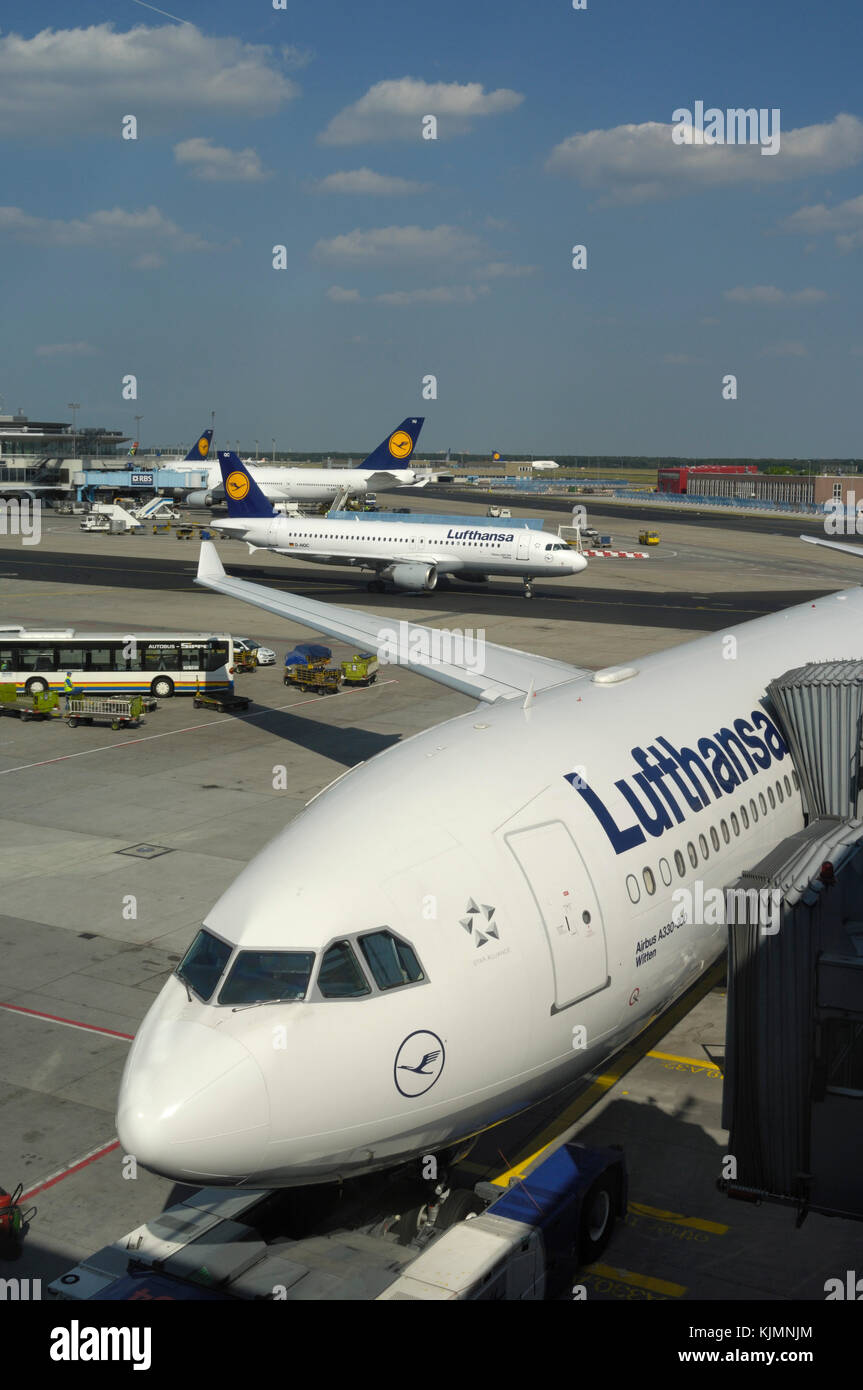 Lufthansa Airbus A330-300 parked at the gate with A320-200 taxiing and Boeing 747-400s behind Stock Photo