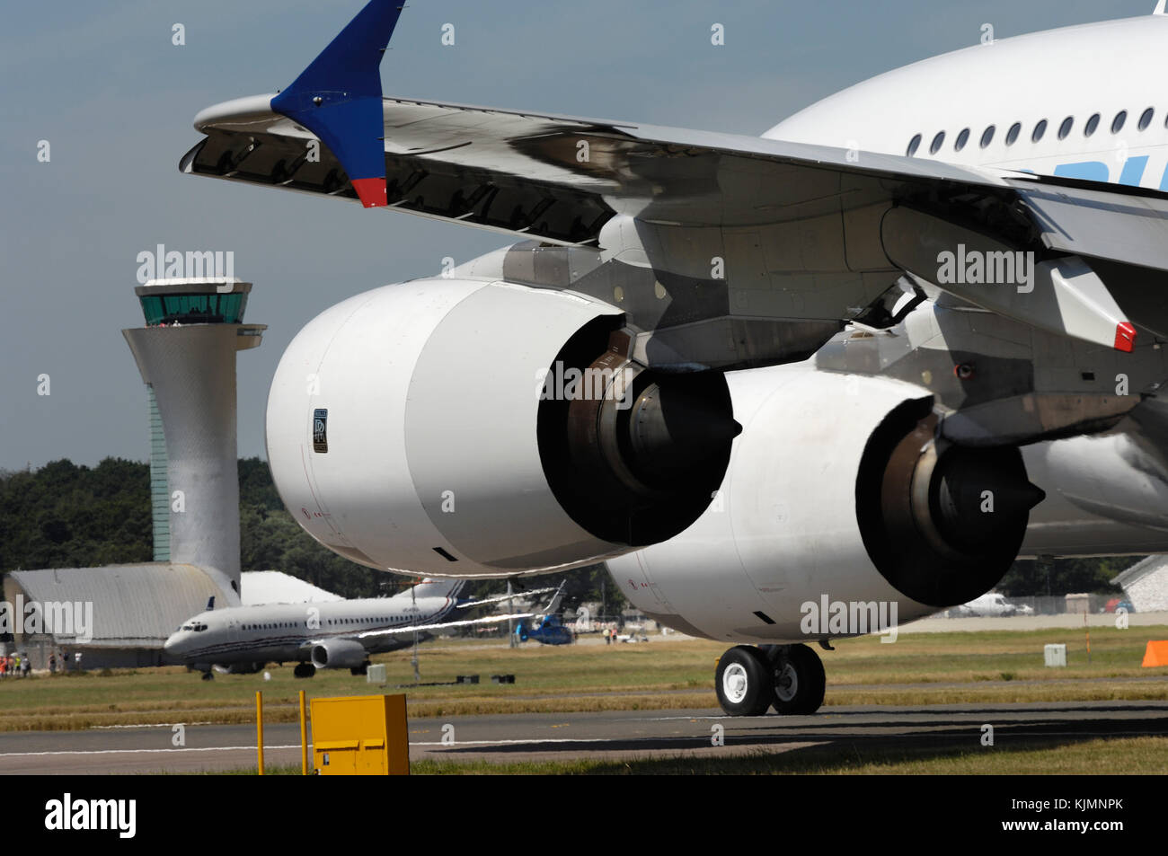 Rolls-Royce Trent 900 engine cowlings, winglet and flaps of the Airbus A380-800 taxiing with the air-traffic control-tower behind at the 2006 Farnboro Stock Photo