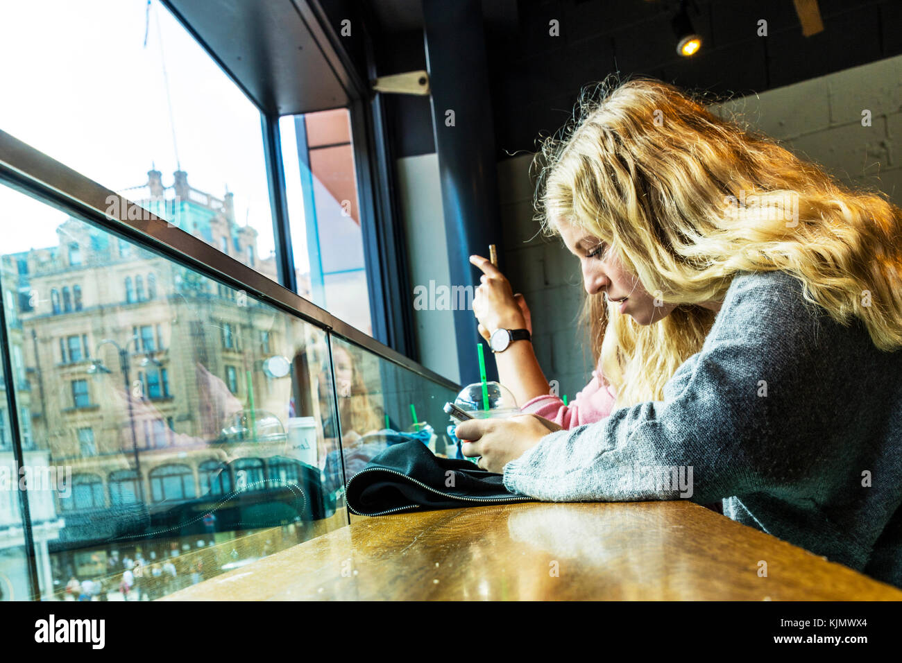 teen girl using mobile phone, teenager playing on mobile phone, using mobile phone, teen using mobile phone, looking at mobile phone, using phone, Stock Photo