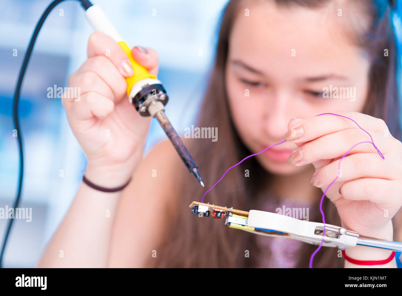 Schoolgirl in electronics class uses a soldering iron Stock Photo Alamy