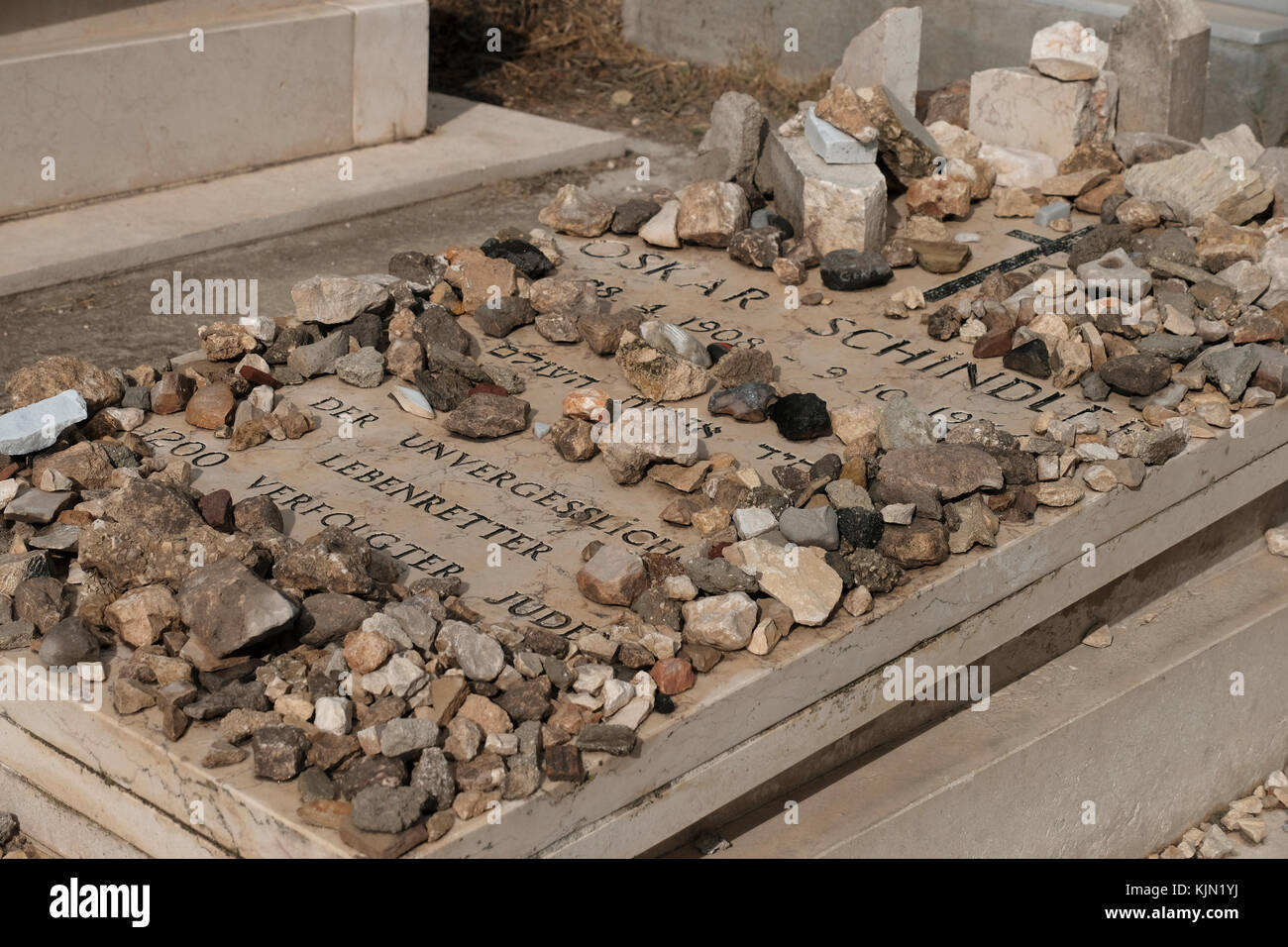 Stones placed in sign of gratitude by Jewish visitors on the grave of Oskar Schindler who was a German industrialist and a member of the Nazi Party, who is credited with saving the lives of 1,200 Jews during the Holocaust located in the Roman Catholic Franciscan cemetery on Mount Zion Jerusalem Israel Stock Photo