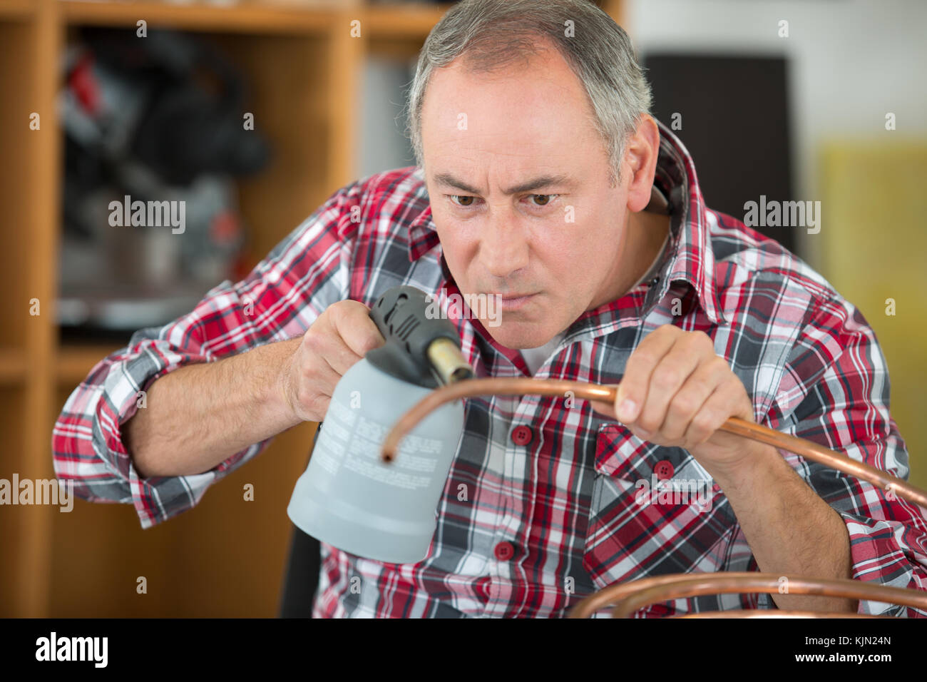 Man Using Blowtorch Man concentrating while using blow torch Stock Photo - Alamy