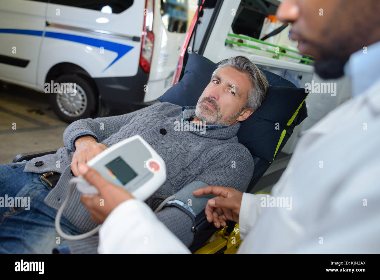 Ambulance man monitoring heartrate of patient Stock Photo - Alamy