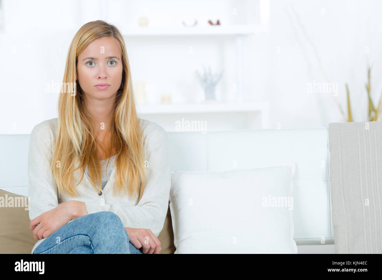 portrait of beautiful young blonde woman sitting on the sofa Stock ...