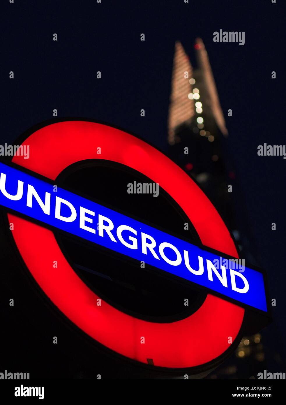 London, England, United Kingdom–November 13 2017. Iconic London underground sign and the Shard with a dark background, taken in the night. Stock Photo
