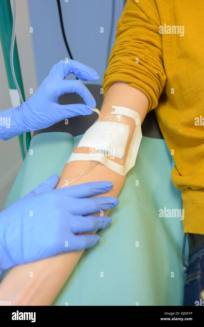 nurse removing iv needle with selective focus Stock Photo
