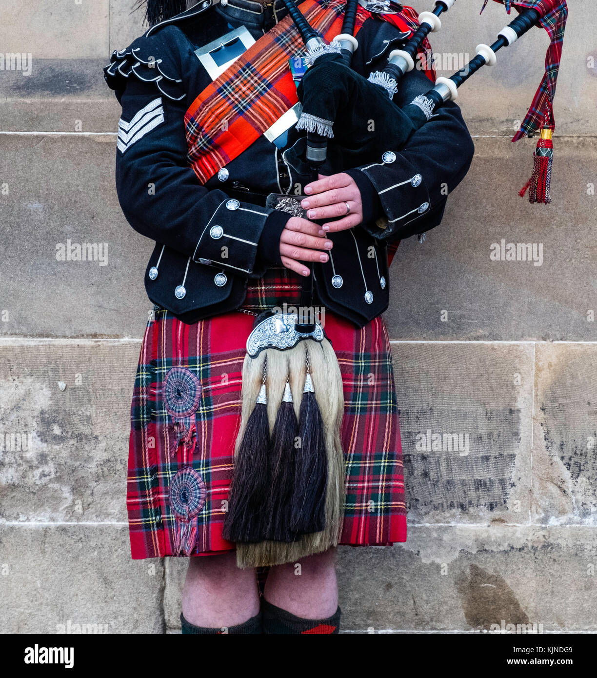 Scottish man wearing traditional tartan and kilt playing bagpipes on Royal Mile in Edinburgh Old Town , Scotland, United kingdom Stock Photo