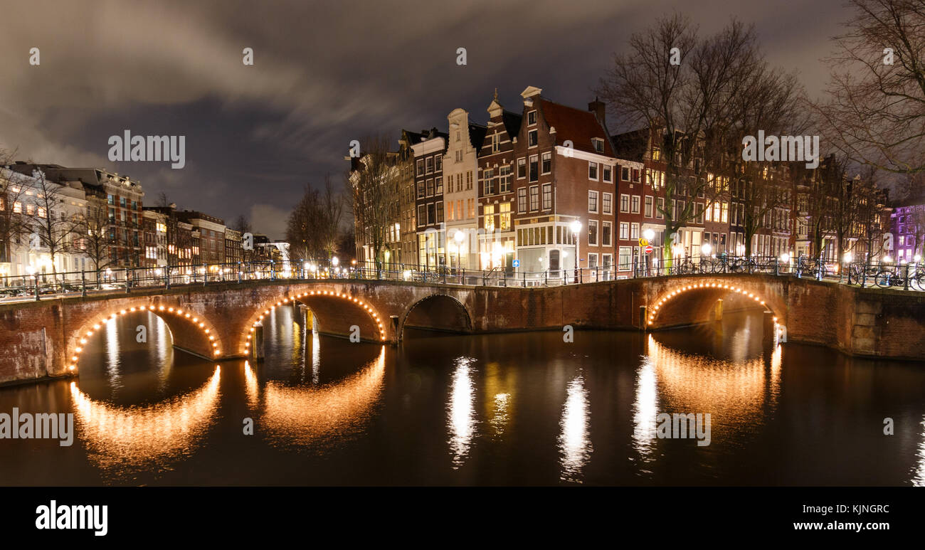 Beautiful night scene in Amsterdam at Keizersgracht and Leidsegracht with illuminated bridges in winter. This spot is a famous Photo-Location. Stock Photo
