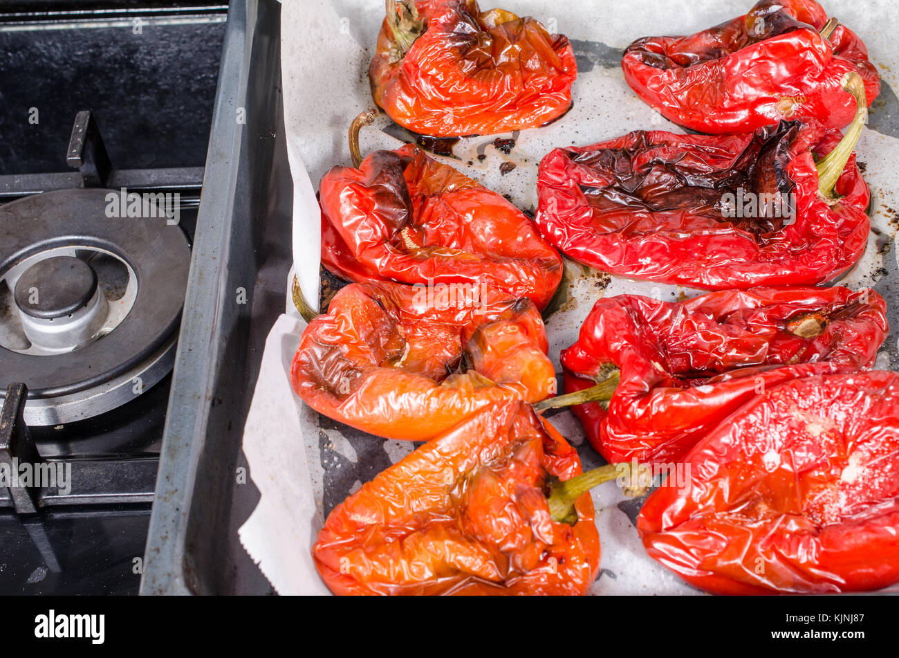 Freshly grilled red peppers on an oven tray Stock Photo - Alamy