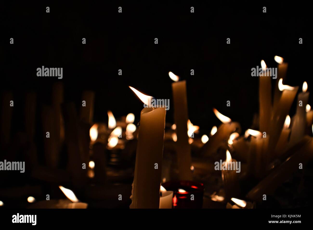 Slow burning wax candles in church as a symbol of death memory. Dark