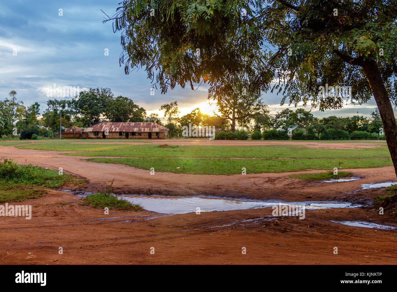 Sunset after a heavy shower in Mbale Uganda. Looking at the local soccer field with the primary school in the background. Stock Photo