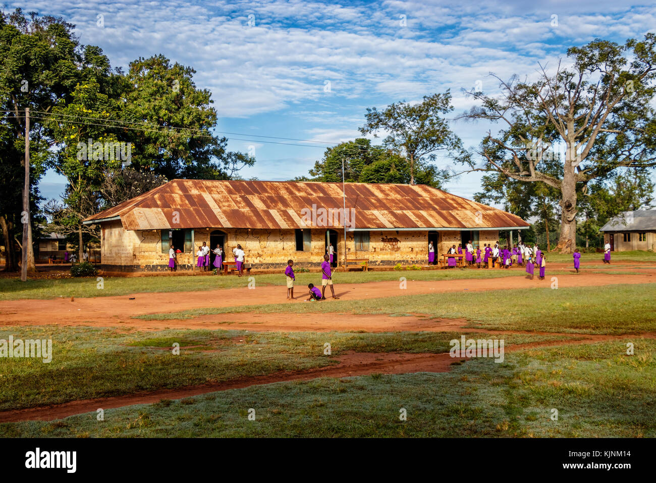 KOLONYI, UGANDA – NOVEMBER 09, 2017: Many students with purple uniform waiting to enter the primary school in Kolonyi near Mbale in Uganda on a beauti Stock Photo