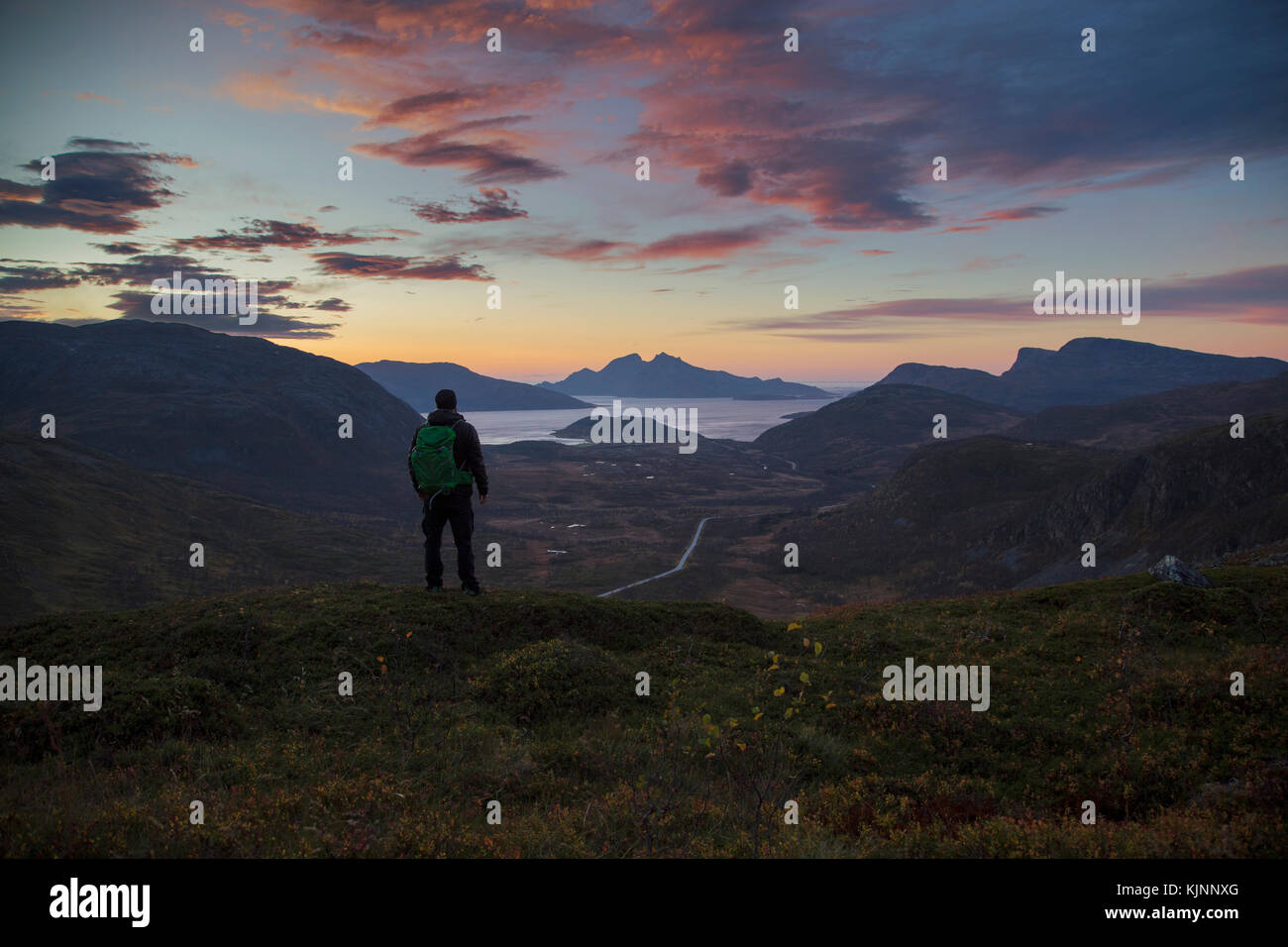 Backpacker looking and a beautiful sunset over the Norwegian fjords Stock Photo - Alamy