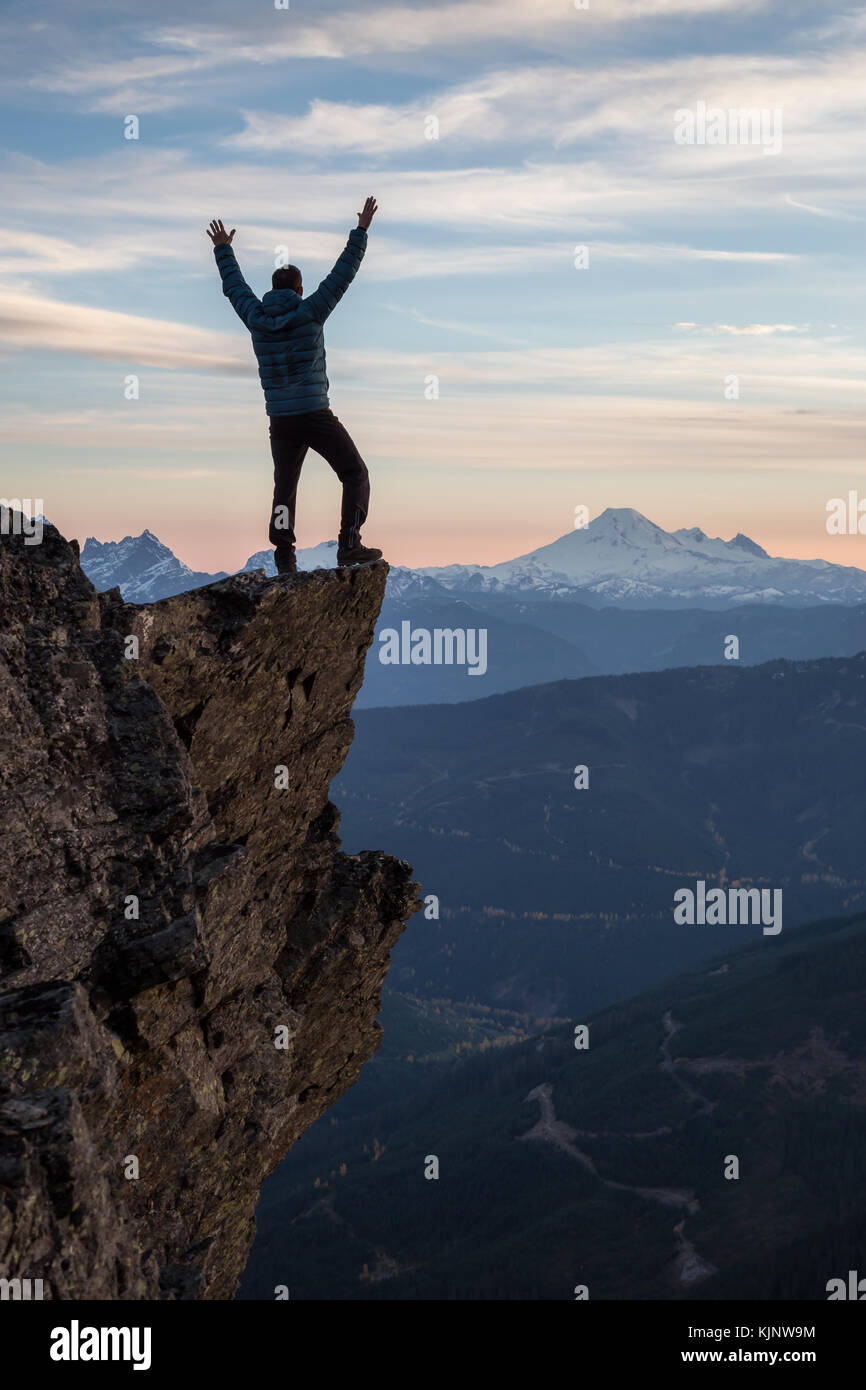 Adventurous Man Is Standing On Top Of The Mountain And Enjoying The Stock Photo Alamy