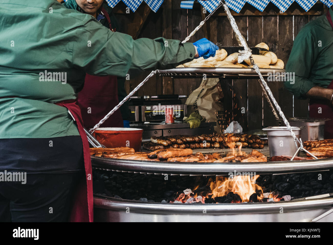 Staff cooking German sausages at Winter Wonderland, an annual Christmas fair in Hyde Park, London, UK Stock Photo