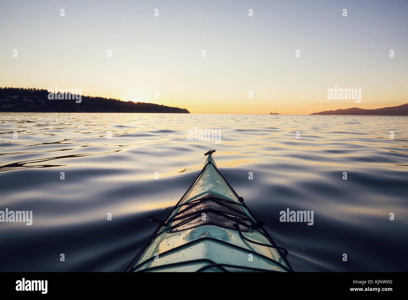 Sea kayaking in the ocean during a colorful and vibrant sunset. Taken ...