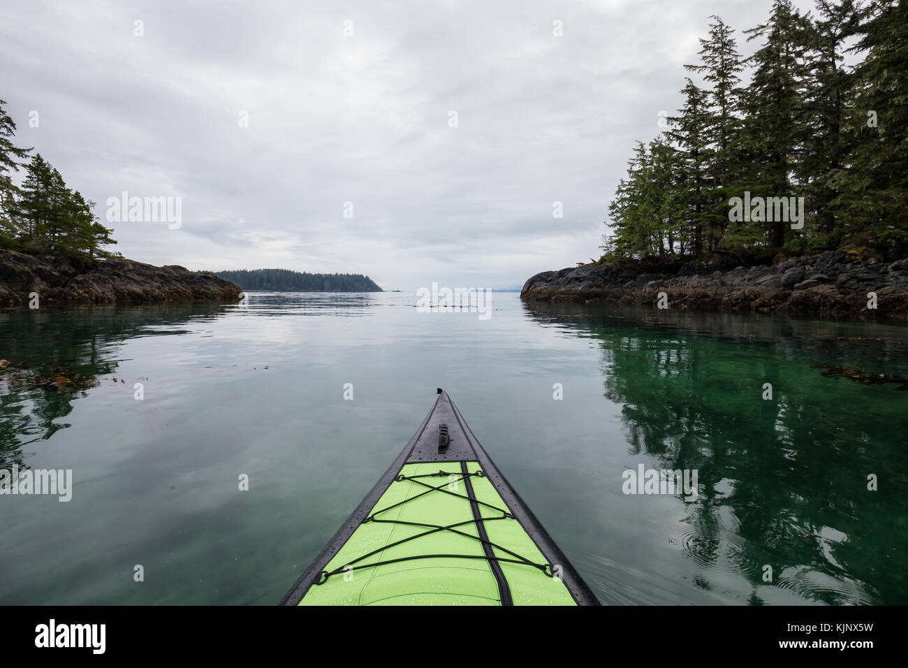 Kayaking on an inflatable kayak in the peaceful ocean by rocky islands