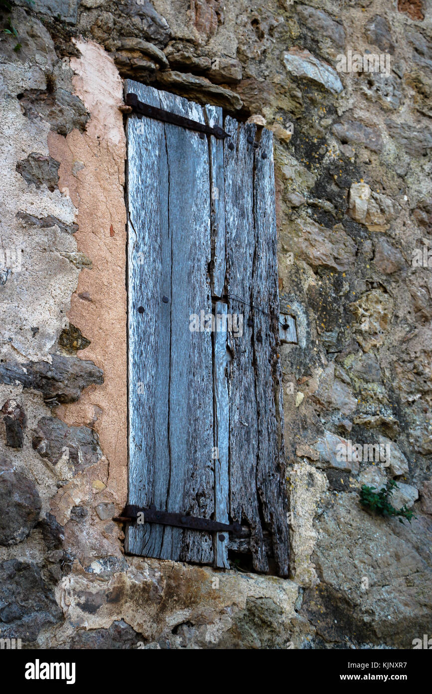 Closed Old External Timber Window Shutter in Rustic Stone Wall Spain Stock Photo