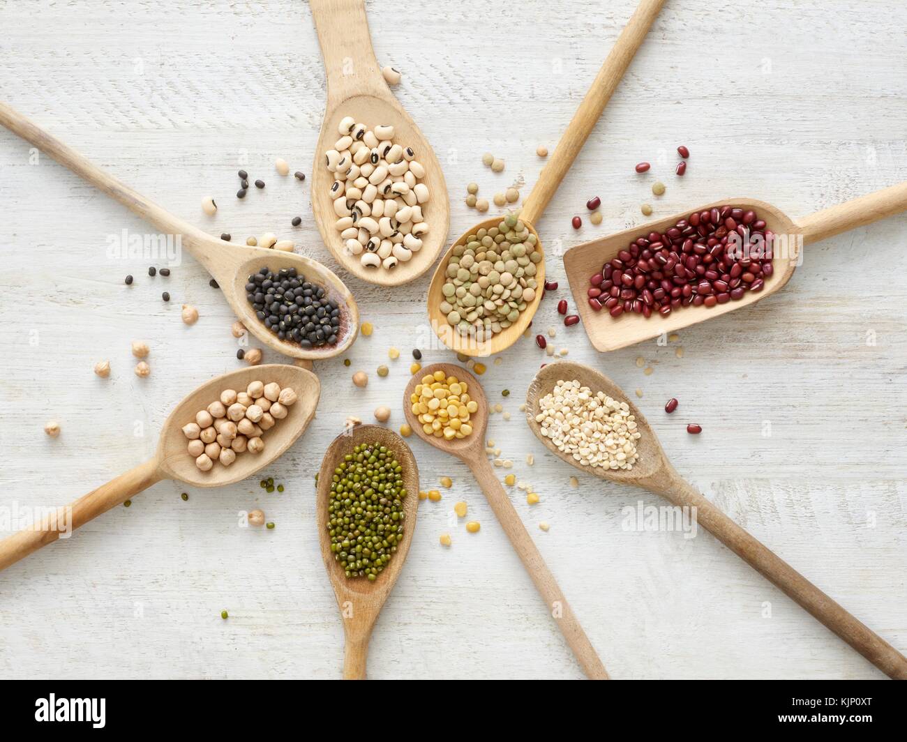Pulses on wooden spoons, overhead view. Stock Photo
