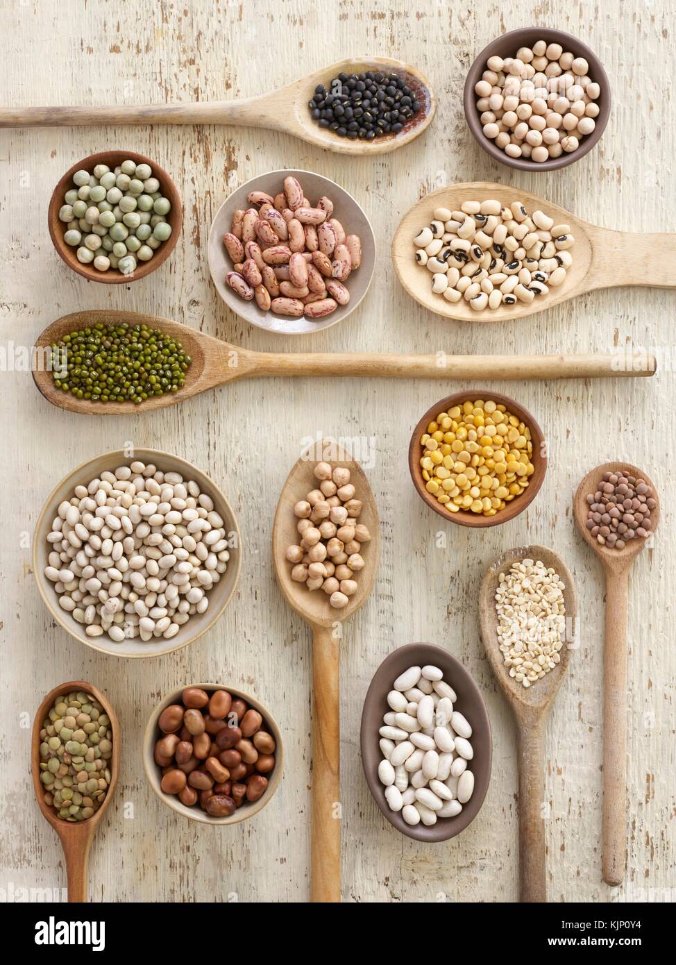 Pulses on wooden spoons, overhead view. Stock Photo