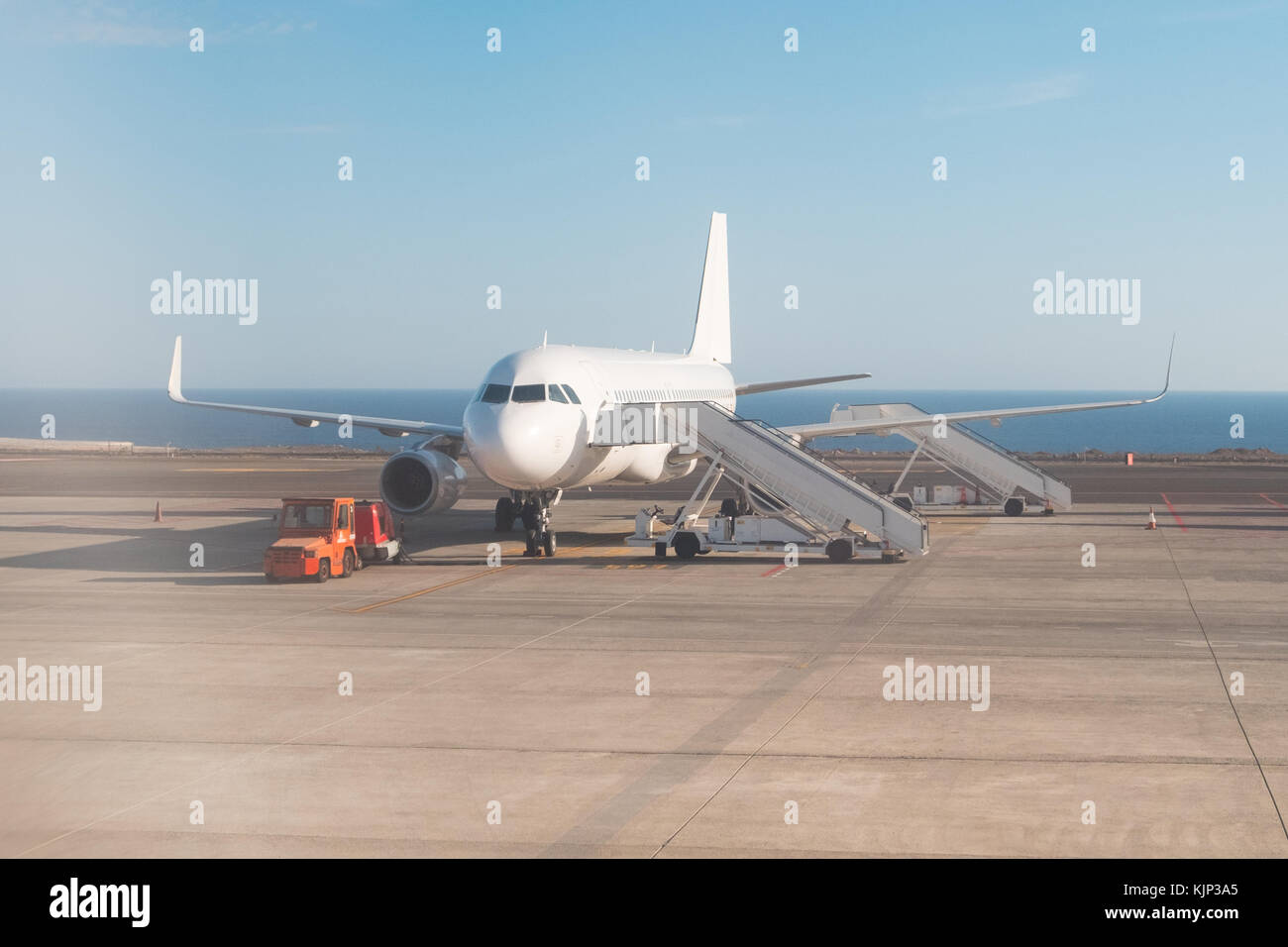 airplane standing on runway with stairs ready for boarding, Stock Photo