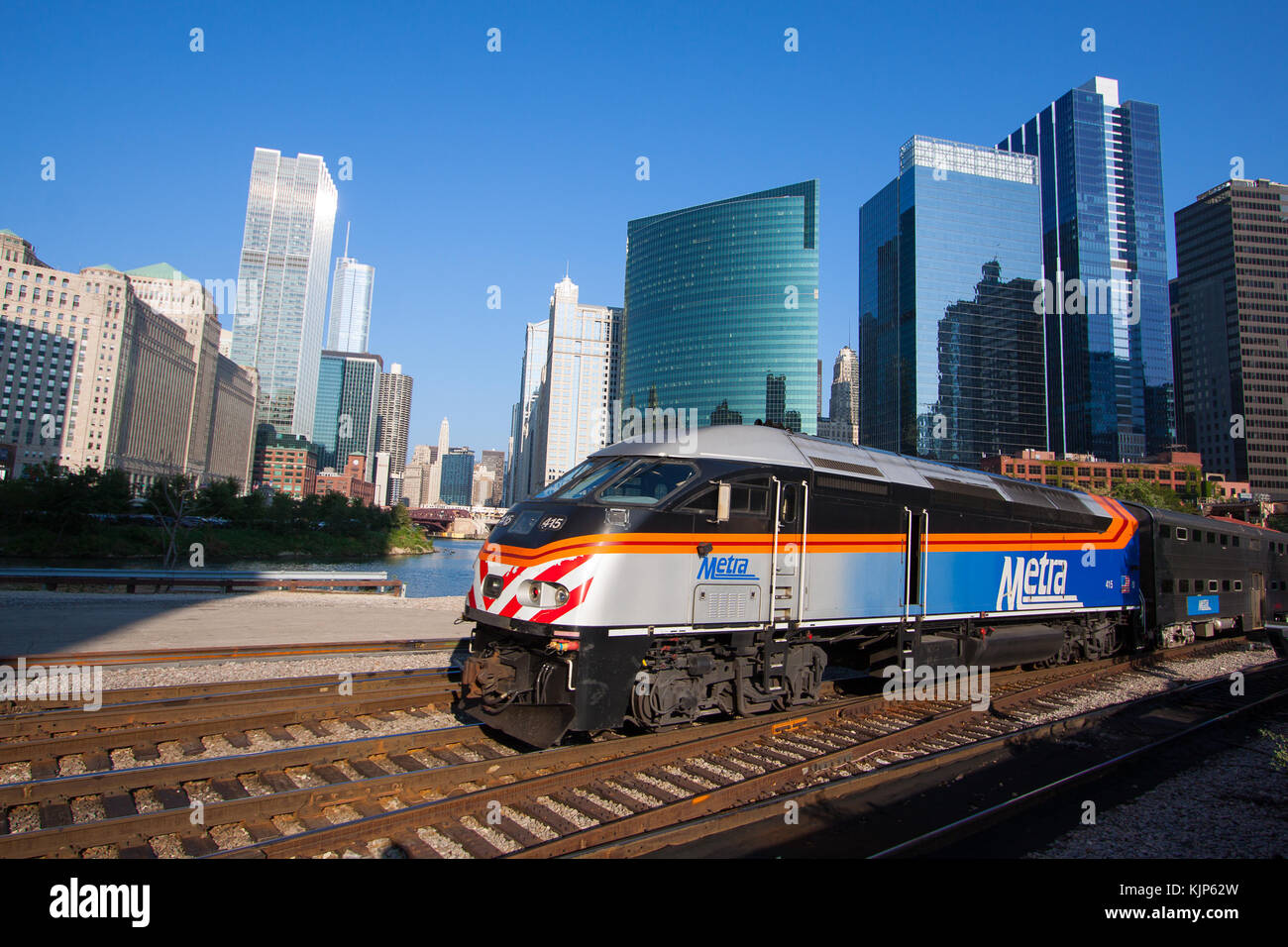 Leaving Chicago's Union Station with a train load of commuters, a Metra train rushes north along the Chicago River. Stock Photo