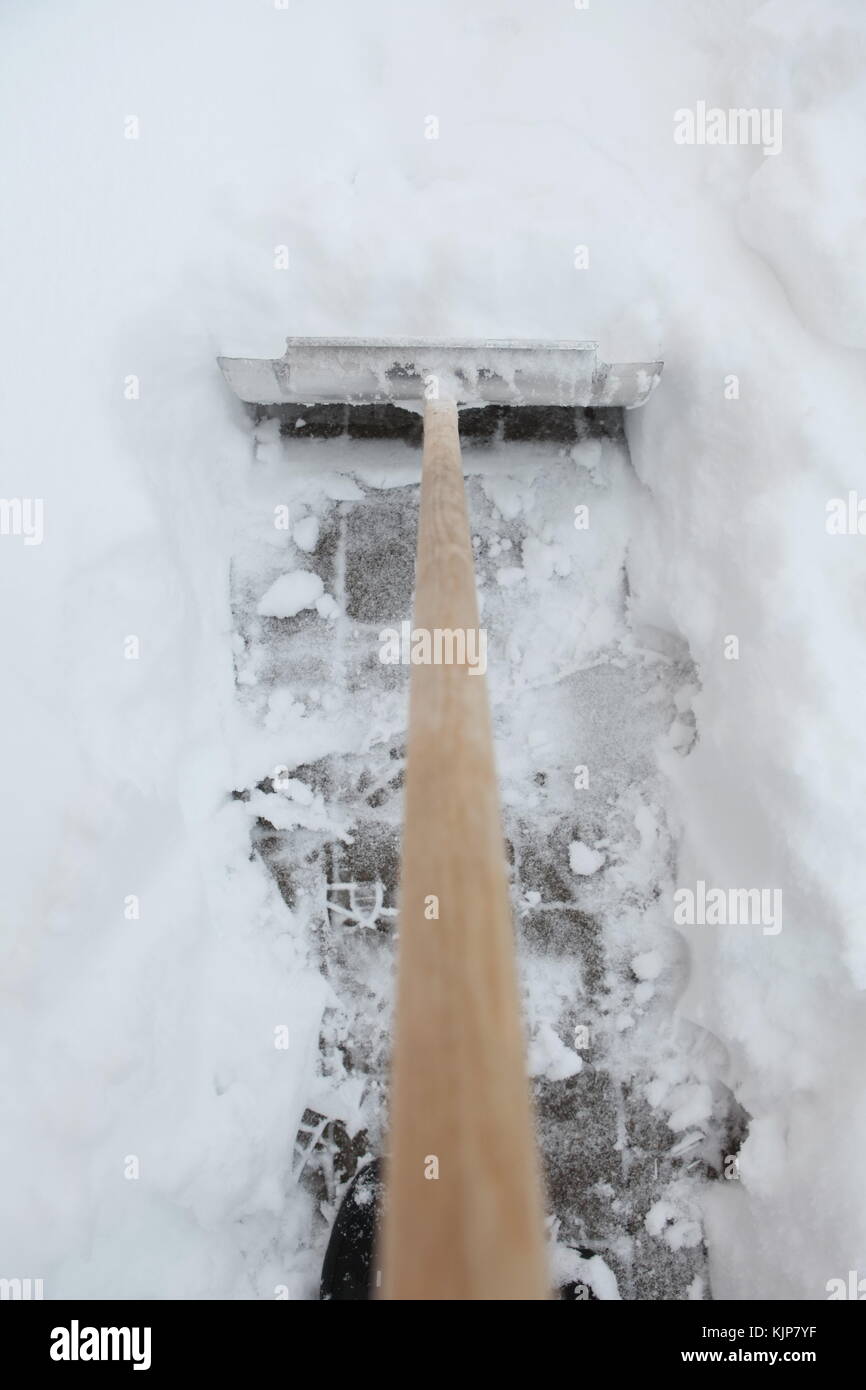 Shoveling snow from driveway shovel in snow Stock Photo Alamy
