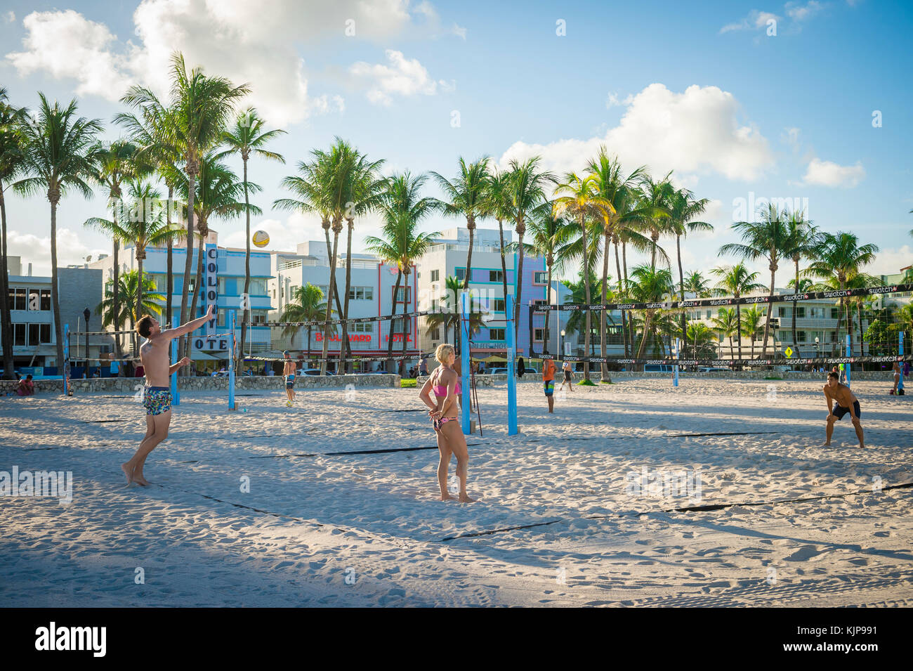 MIAMI - August 31, 2017: Young men and women play beach volleyball on the promenade in Lummus Park against the Art Deco skyline of Ocean Drive. Stock Photo