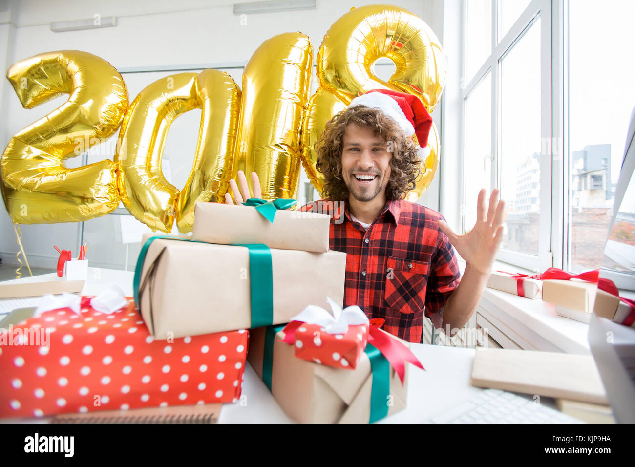 Laughing man in xmas hat expressing gladness of holidays and looking at camera Stock Photo