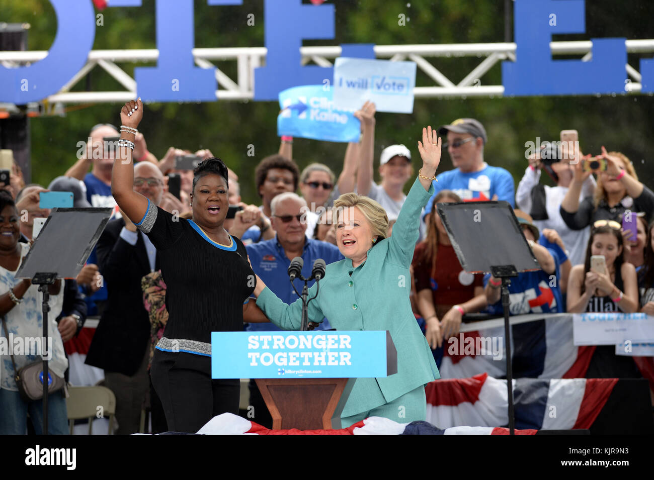 PEMBROKE PINES, FL - NOVEMBER 05: Supporters look in the pouring rain on as Democratic presidential nominee and former Secretary of State Hillary Clinton speaks during a campaign rally at C.B. Smith Park on November 5, 2016 in Pembroke Pines, Florida. With three days to go until election day, Hillary Clinton is campaigning in Florida and Pennsylvania  People:  Hillary Clinton Stock Photo