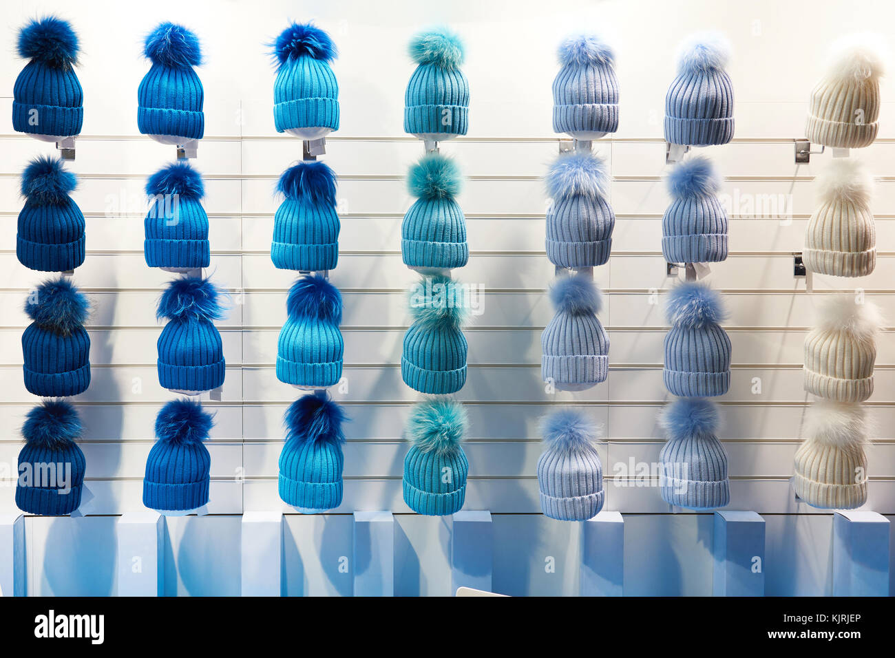 Winter hats of blue hues in the shop window Stock Photo