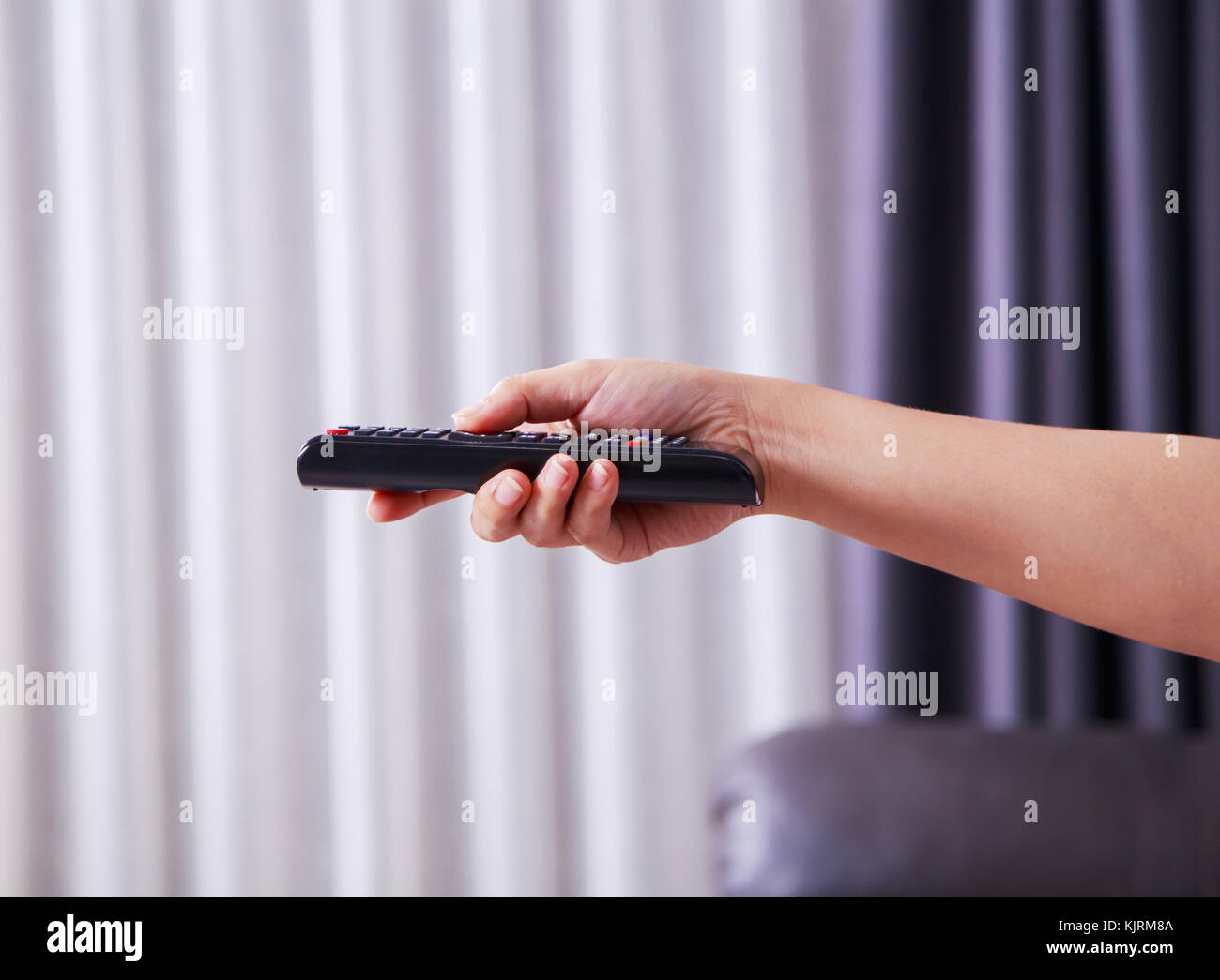 close up of remote tv in hand Stock Photo