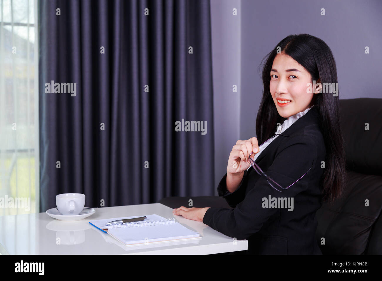 happy young business woman sitting at the desk Stock Photo - Alamy