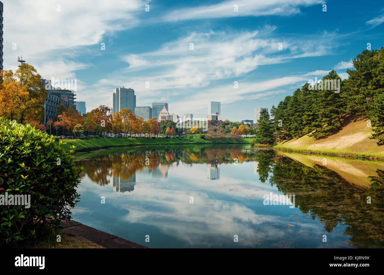 View of the Tokyo city center from the Imperial Palace public gardens ancient moat in autumn Stock Photo
