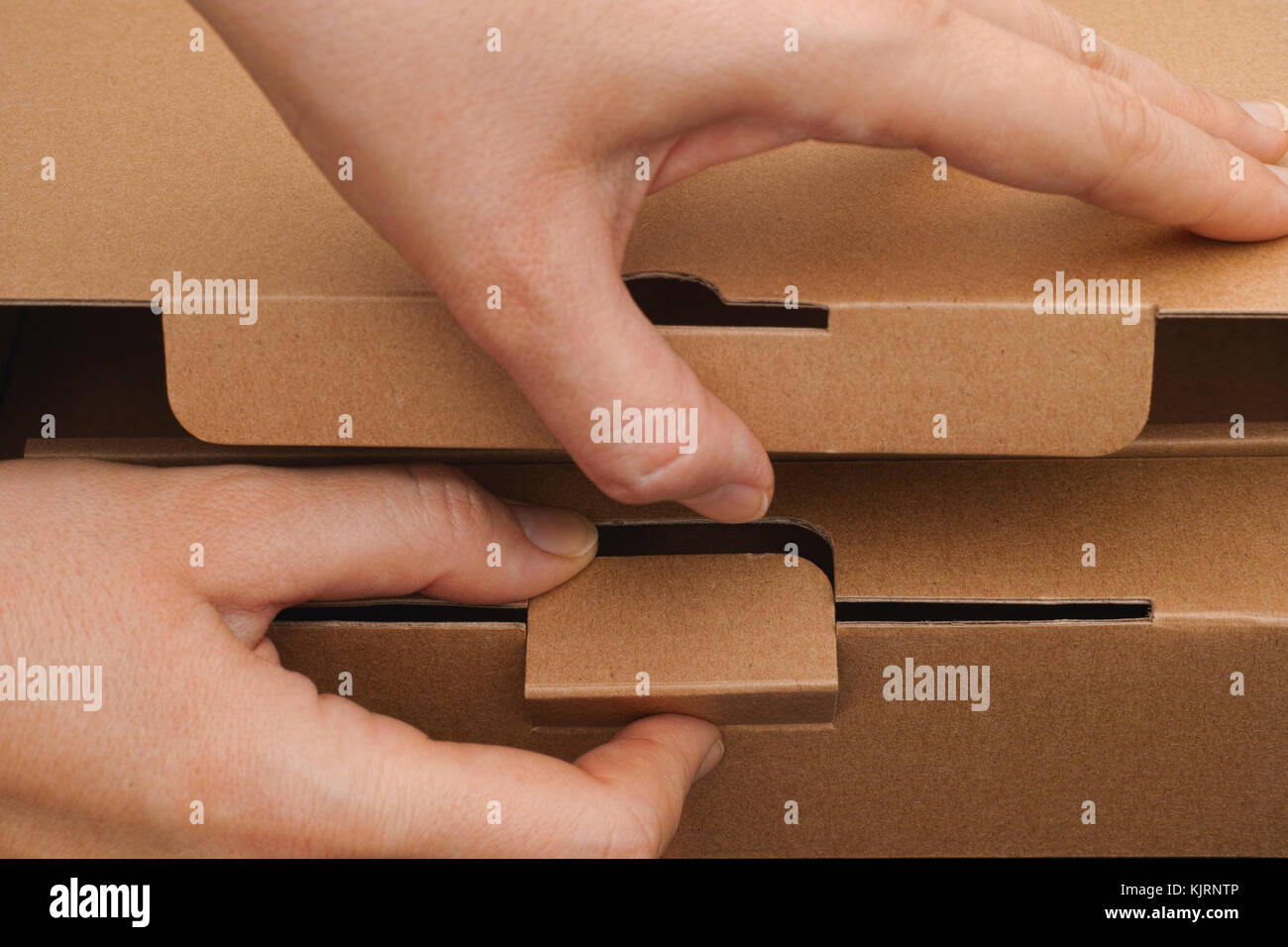 Person hands opening a cardboard box. Close-up. Stock Photo