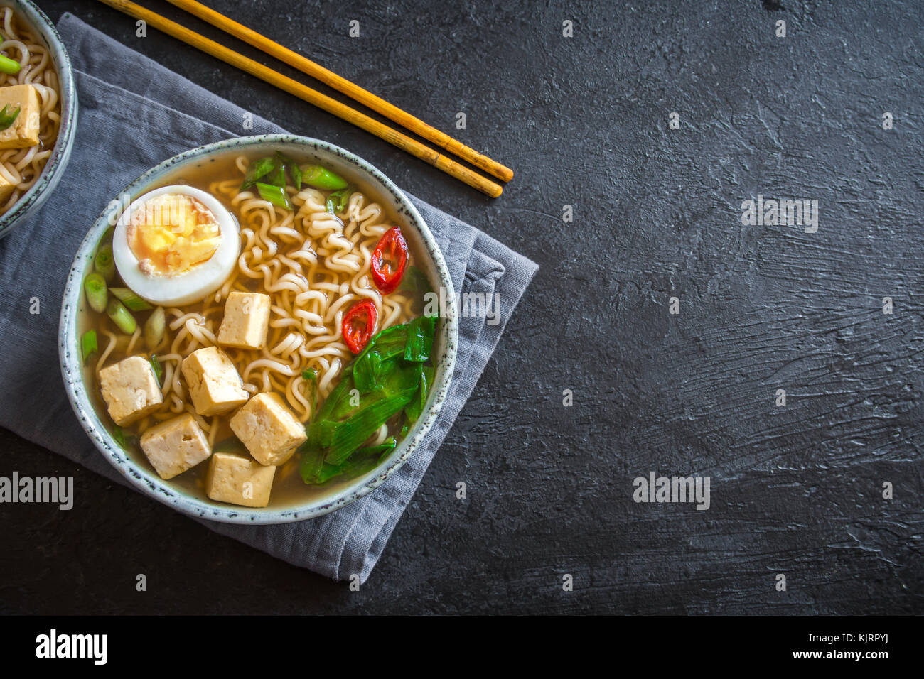 Japanese ramen soup with tofu and egg on dark stone background. Miso