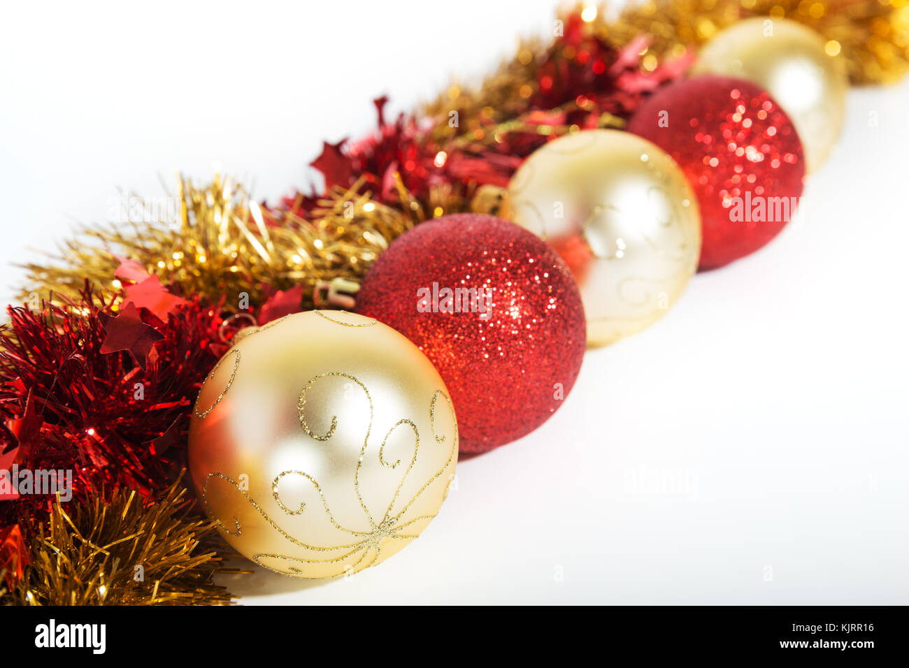 Christmas decorations ofred and golden color on a white background - balls and tinsel Stock Photo